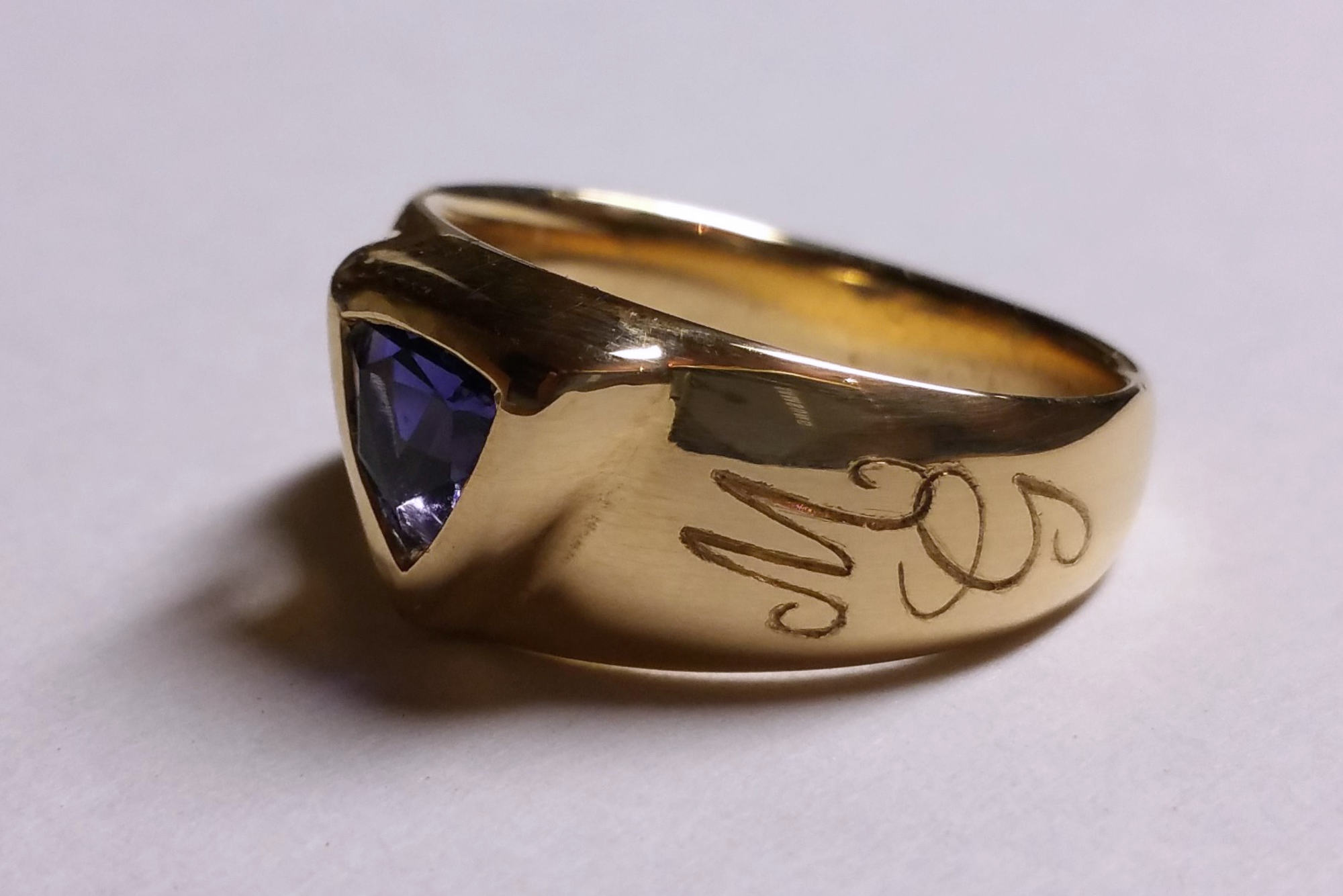 Personnalisation d'une bague en or jaune avec des initiales entrelacées