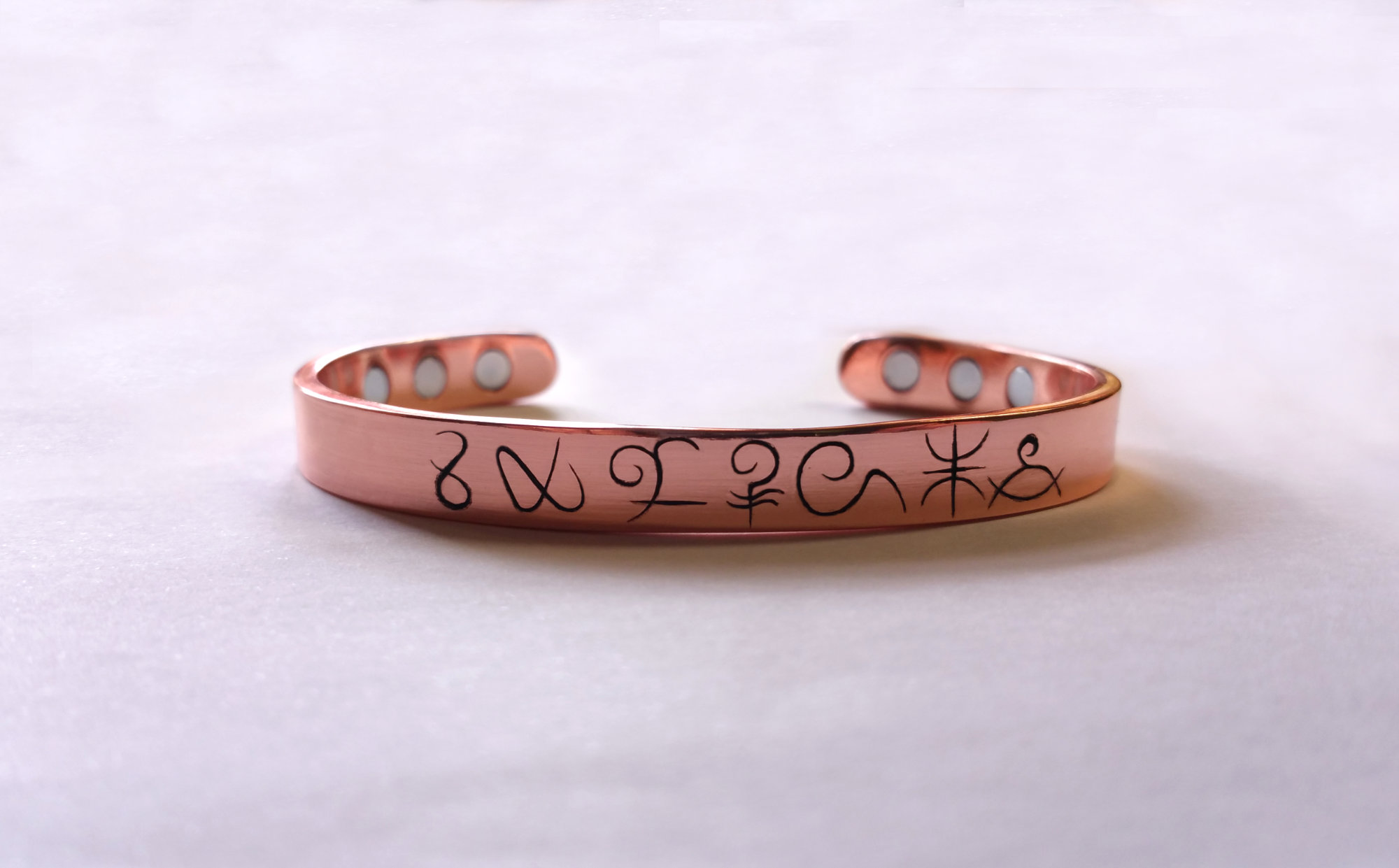 Bracelet en cuivre gravé d'un symbole personnel choisi par le client