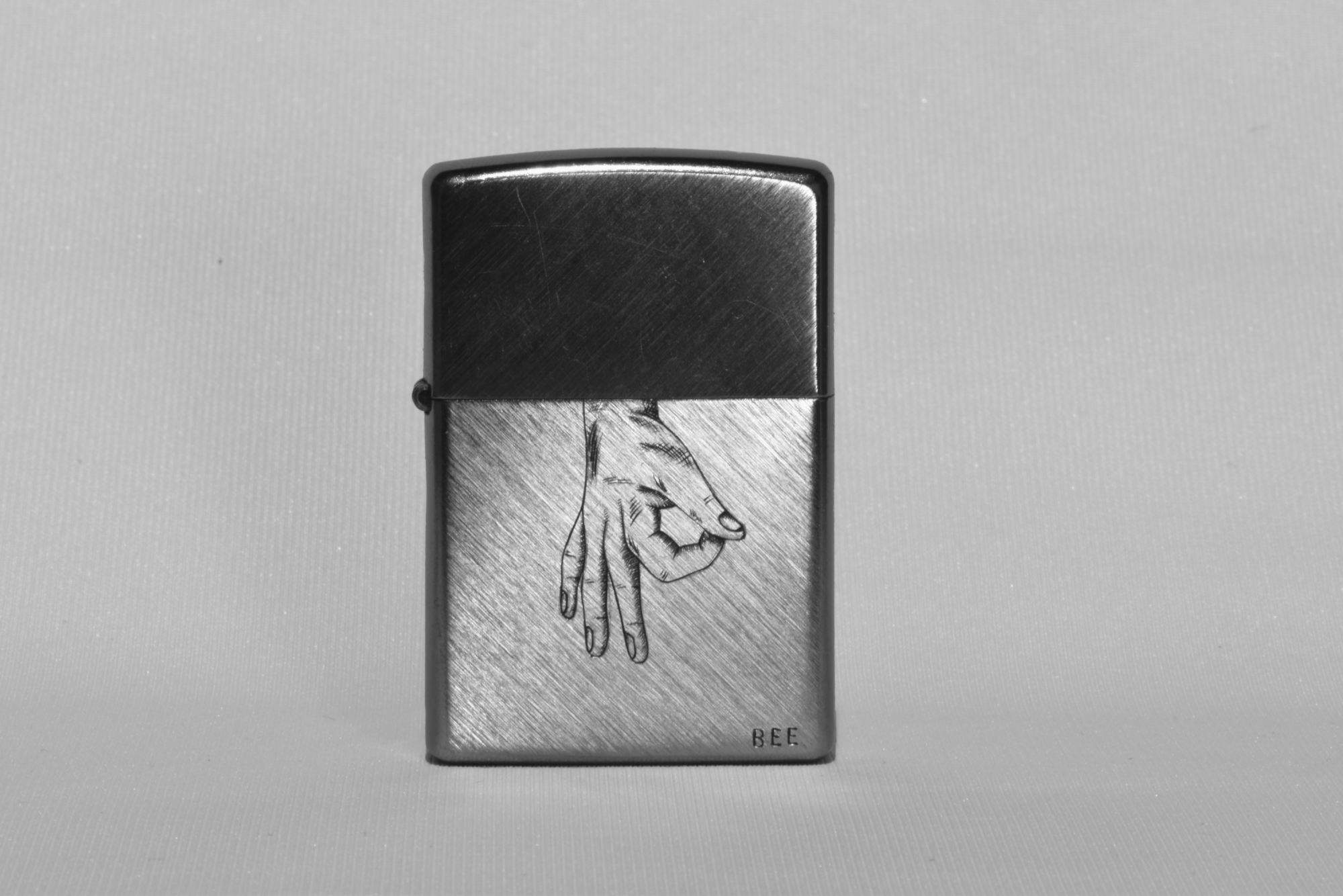 Briquet Zippo en métal argenté, motif main figurative gravée en taille douce