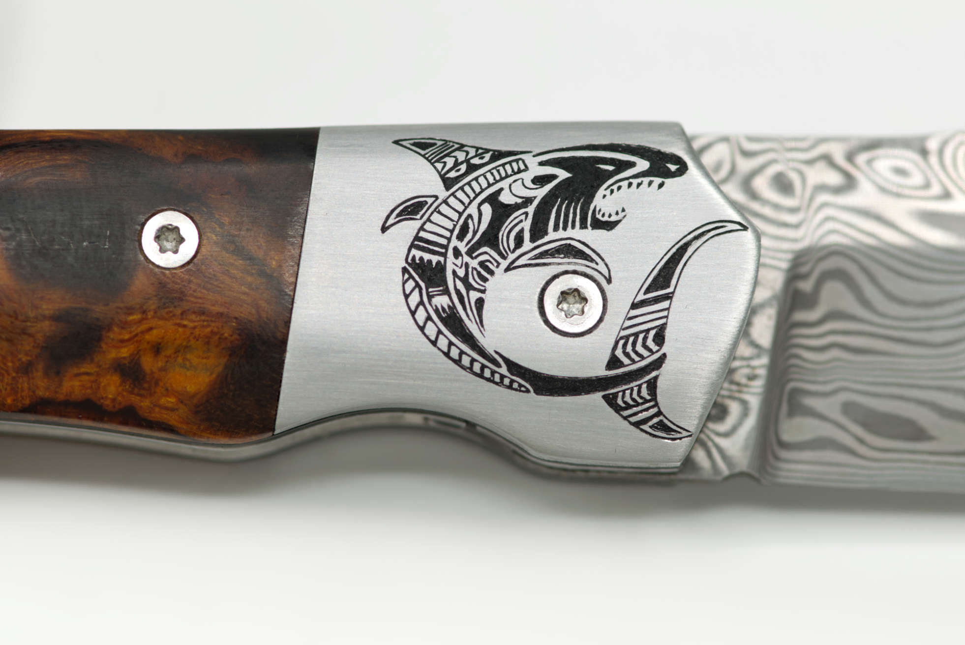 Gros plan verso : détail de la gravure d'un Requin stylisé (motif Maoris) sur mitre en inox