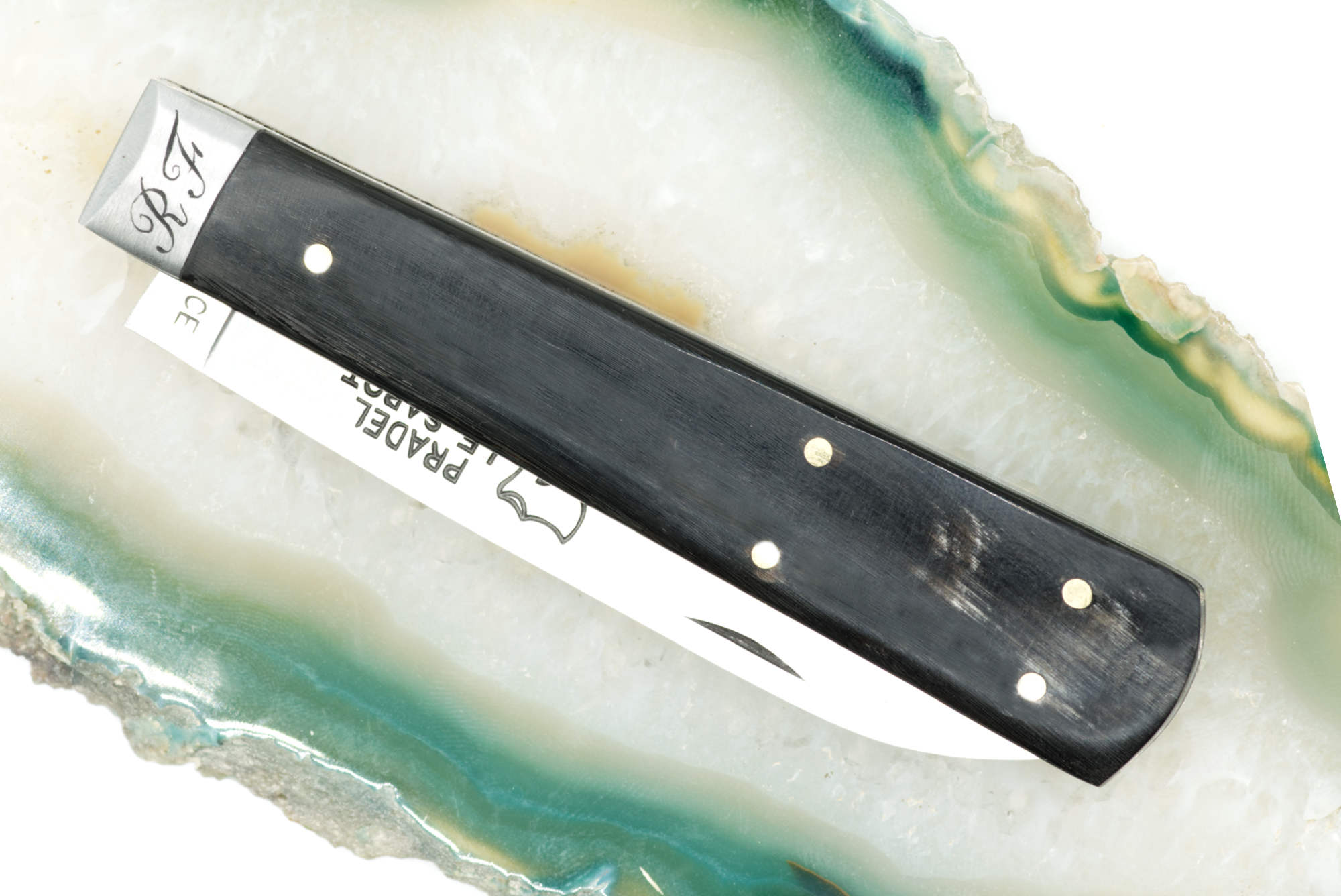 Couteau personnalisé : initiales R.F gravées à la main sur mitre en inox, technique taille douce